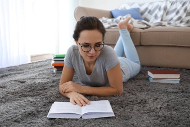 Genç kadın katta evde kitap okuma