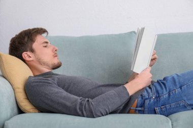 Evde istirahat ederken okuma kitabı genç adam