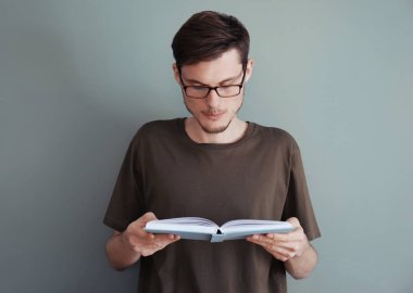 Genç adam renk arkaplanı kitabı okuyor