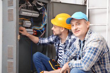 Dağıtım panosu kapalı yakınındaki iki elektrikçiler