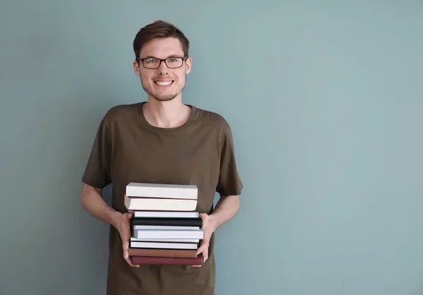 Mladý Muž Hromadou Knih Barvu Pozadí — Stock fotografie