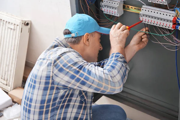 Mature Electrician Repairing Distribution Board Indoors — Stock Photo, Image