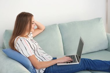 Evde dizüstü bilgisayarda çalışan serbest çalışan bir kadın.