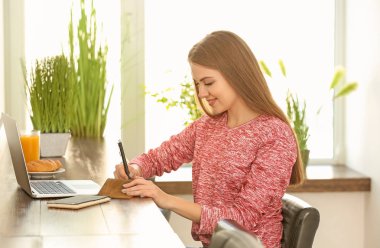 Kafede dizüstü bilgisayar üzerinde çalışan kadın serbest meslek