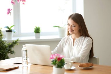 Ev ofis içinde laptop üzerinde çalışan kadın serbest meslek
