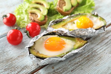 Yumurta ve ahşap arka plan üzerinde sebze pişmiş avokado