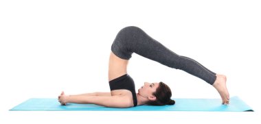 Beyaz arka planda yoga yapan genç bir kadın.