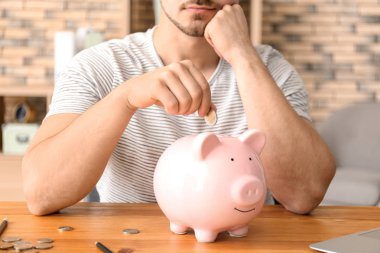 Adam para kumbara kapalı koyarak. Para tasarruf kavramı