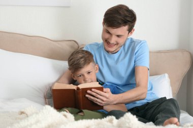 Baba ve oğlu birlikte evde kitap okuma