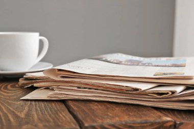 Gazeteler yığını ile çay ahşap tablo
