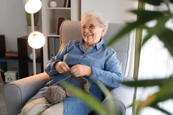 Senior Mulher Sentada Poltrona Enquanto Tricô Suéter Casa — Fotografia de Stock