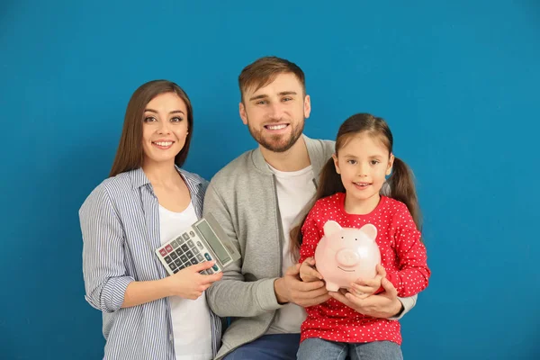 Familia Joven Feliz Con Alcancía Calculadora Sobre Fondo Color —  Fotos de Stock