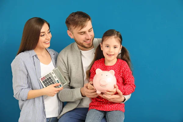 Jovem Família Feliz Com Banco Porquinho Calculadora Fundo Cor — Fotografia de Stock