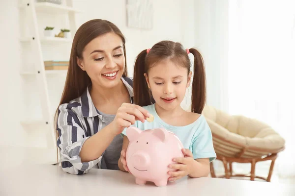 Niña Con Madre Sentada Mesa Poniendo Moneda Alcancía Interior Concepto —  Fotos de Stock