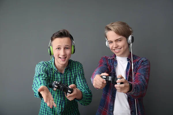 Adolescentes Con Gamepads Sobre Fondo Gris —  Fotos de Stock