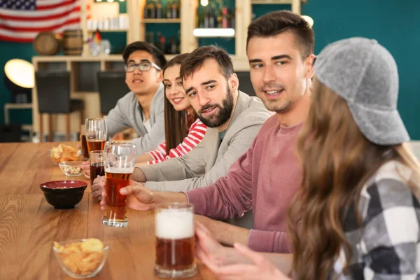 Group of friends drinking beer in bar