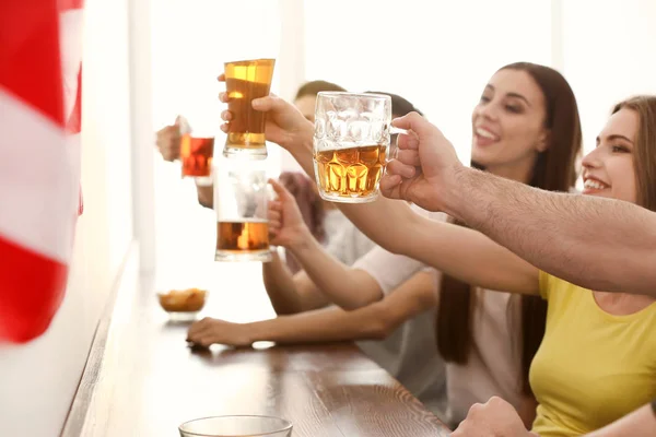 Group of cheerful friends drinking beer in bar