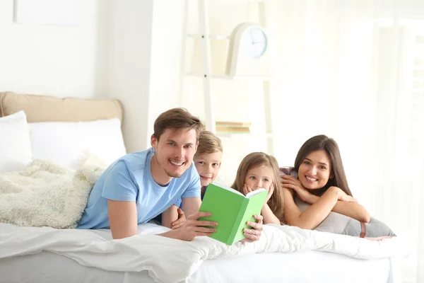 快乐的家人一起在卧室看书 — 图库照片