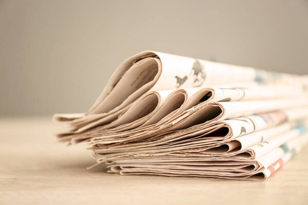Pile of newspapers wooden table