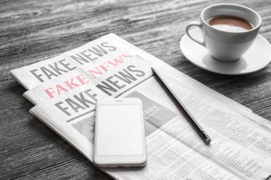 Sabah gazeteleri ve ahşap masa telefonu