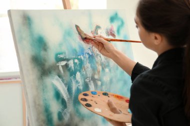 Atölyede resim yapan kadın sanatçı