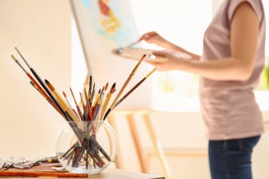 Fırçalar ve sanatçının atölyesinde masada diğer araçlar kümesi