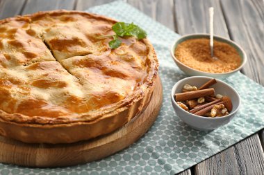 Lezzetli ev yapımı elma pasta ile tarçın, fındık ve şeker ahşap tablo