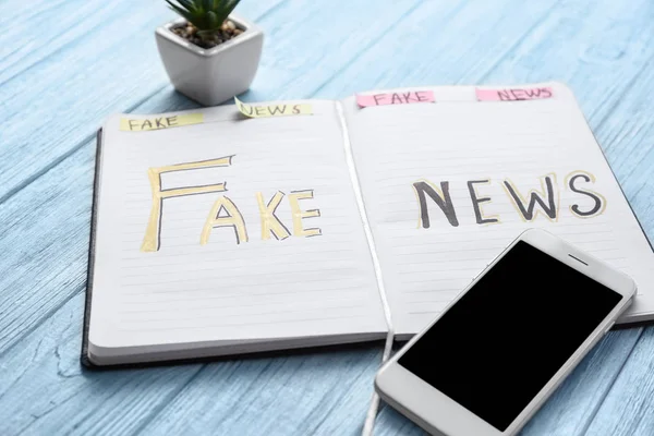 Carnet Avec Mots Fake News Téléphone Portable Sur Fond Bois — Photo