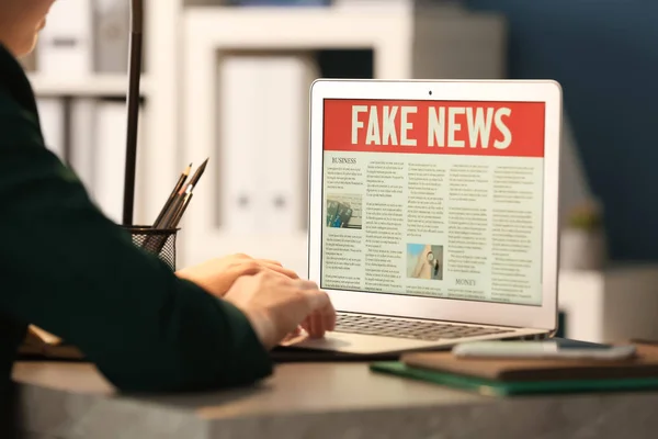 Woman reading news on laptop indoors