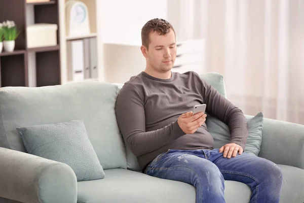 Hombre Joven Usando Teléfono Mientras Descansa Sofá Casa —  Fotos de Stock