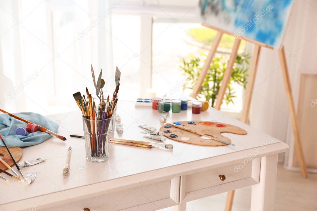 Set of tools with paints on table in artist's workshop