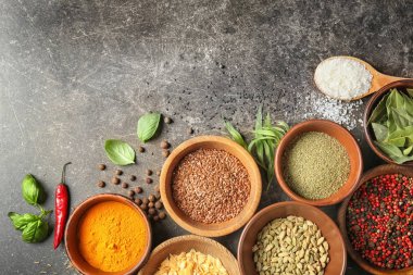 Gri arka plan üzerinde çeşitli baharatlar ile kase