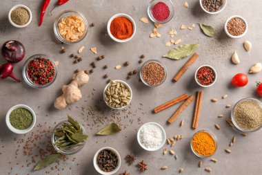 Gri arka plan üzerinde çeşitli baharatlar ile kase