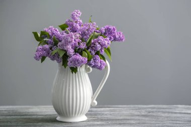 Vazo ile gri arka plan karşı masada güzel çiçek açması leylak