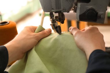 Deri atölye çalışmasında, closeup dikiş makinesi kullanan adam
