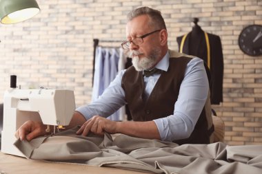 Olgun terzi dikiş makinesi atelier içinde çalışma