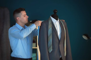 Atelier manken üzerinde ceket ölçümleri alarak genç terzi