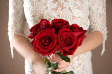 Güzel güller renk arka planda, closeup tutan kadın