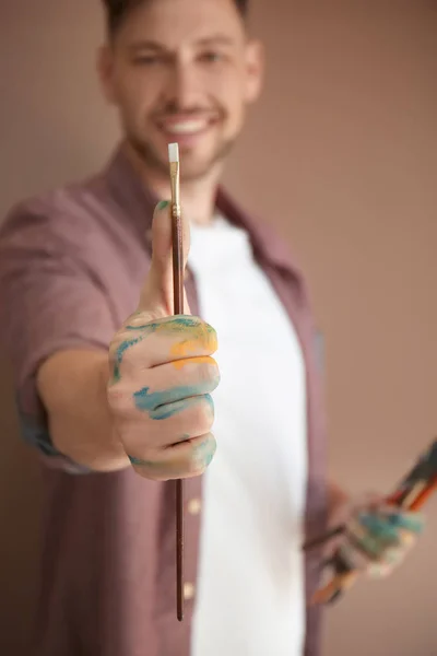 男性艺术家持有画笔的颜色背景 — 图库照片