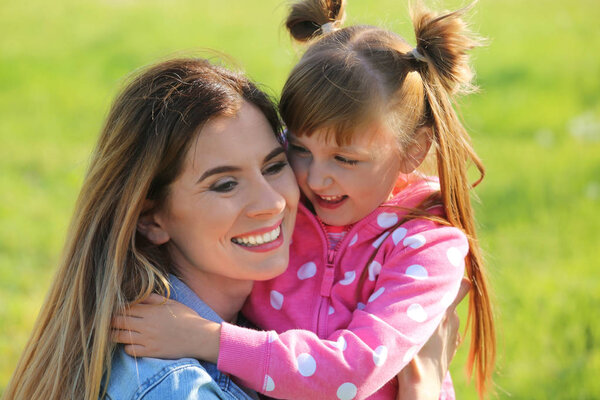 Happy mother and little daughter in park on sunny day