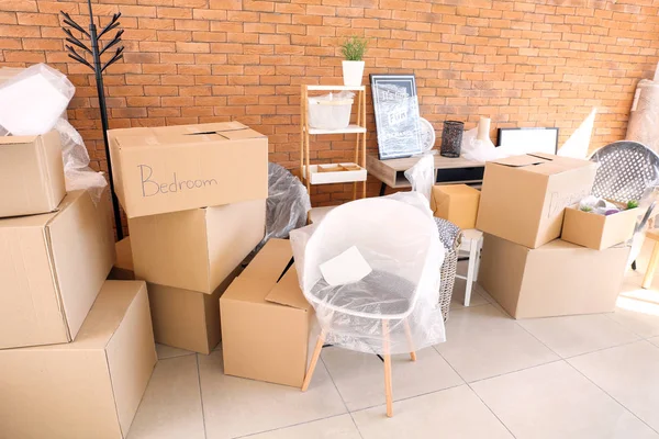Carton boxes and interior items in room. Moving house concept