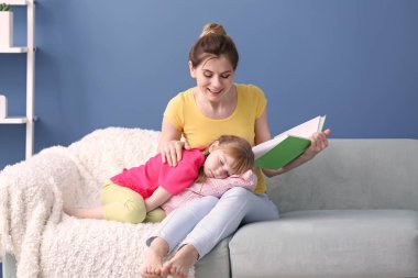 Anne ve kızı evde birlikte kitap okuma