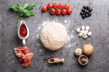 Çiğ hamur ve malzemeler için pizza üzerinde gri dokulu arka plan kompozisyonu