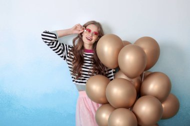 Renkli balonları olan güzel bir genç kadın.