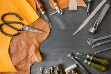 Deri el sanatları ile koyu ahşap arka plan üzerinde araçları
