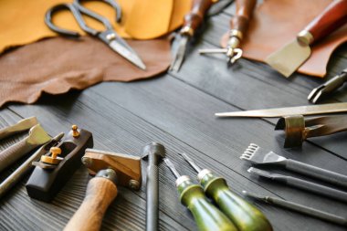 Deri el sanatları ile koyu ahşap arka plan üzerinde araçları