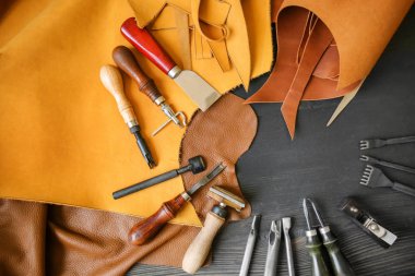 Deri el sanatları ile koyu ahşap arka plan üzerinde araçları