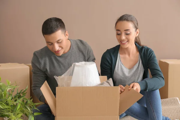 Young Couple Unpacking Box Indoors Moving New House — Stock Photo, Image