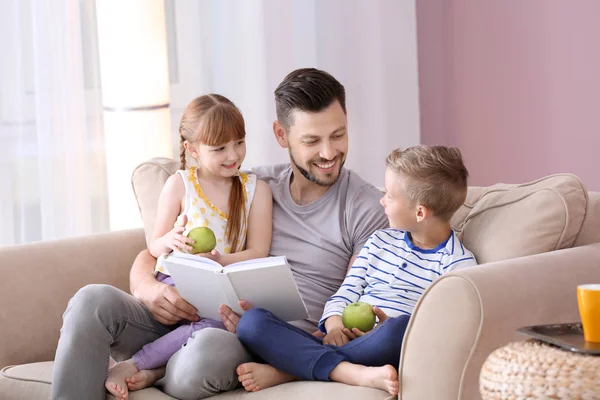 父亲和他的孩子们一起在家里看书 — 图库照片