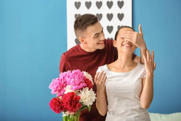 Young Man Giving Beautiful Flowers His Beloved Girlfriend Indoors — Stock Photo, Image